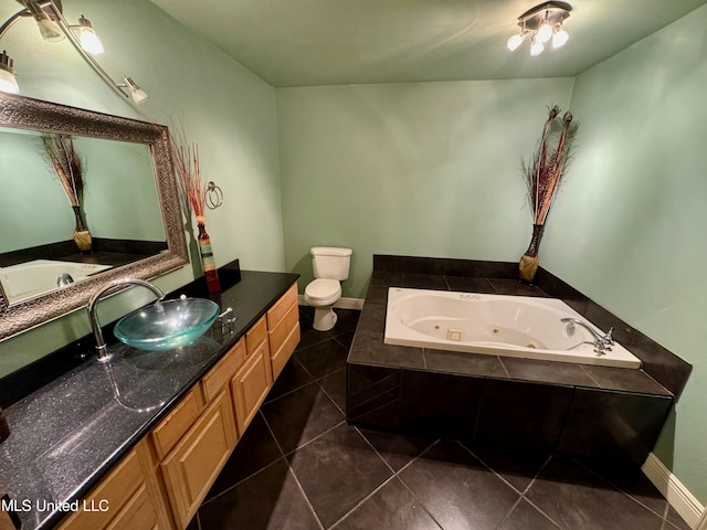 bathroom featuring tile patterned flooring, vanity, toilet, and tiled tub