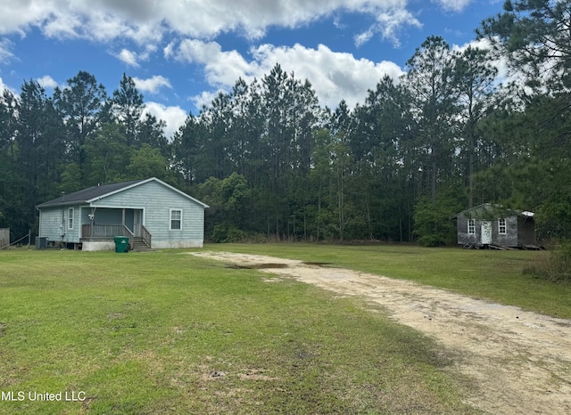 view of yard with cooling unit, an outdoor structure, and covered porch