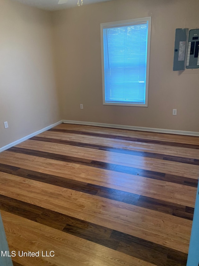 unfurnished room with wood-type flooring and electric panel