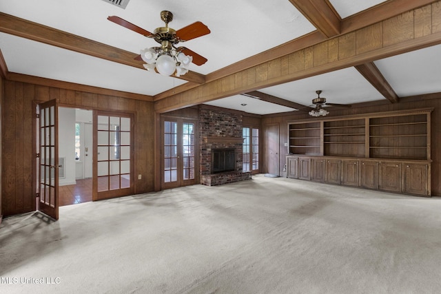 160 Marblehead Ct, Jackson, MS 39211 - unfurnished living room with french doors, a ceiling fan, beam ceiling, wooden walls, and a fireplace