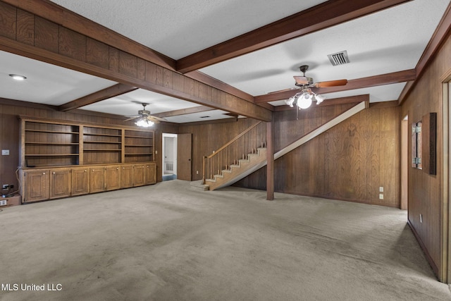 160 Marblehead Ct, Jackson, MS 39211 - unfurnished living room featuring wood walls, ceiling fan, light carpet, stairs, and beam ceiling