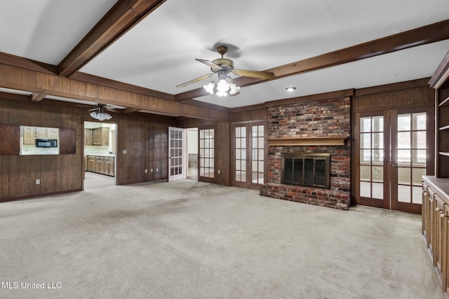 160 Marblehead Ct, Jackson, MS 39211 - unfurnished living room with wooden walls, french doors, beamed ceiling, light colored carpet, and ceiling fan