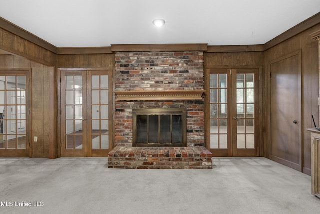 160 Marblehead Ct, Jackson, MS 39211 - unfurnished living room featuring french doors, wood walls, carpet, and a brick fireplace
