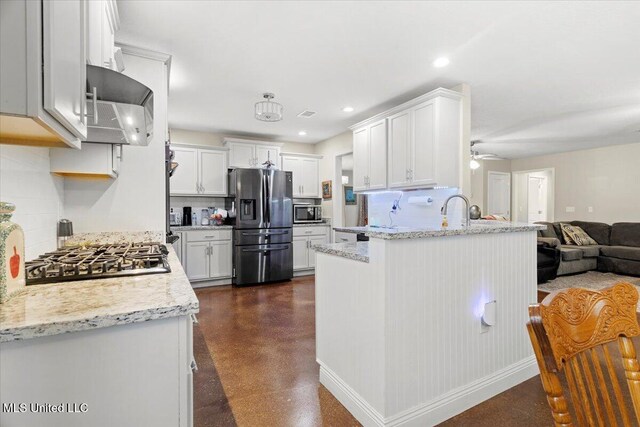 24023 Robert E Lee Rd, Lucedale, MS 39452 - kitchen featuring stainless steel appliances, decorative backsplash, a ceiling fan, a peninsula, and open floor plan