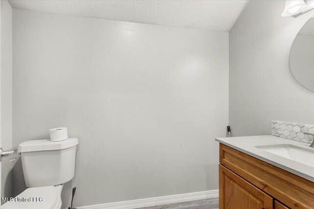 24023 Robert E Lee Rd, Lucedale, MS 39452 - half bath featuring wood finished floors, toilet, and vanity