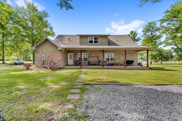 24023 Robert E Lee Rd, Lucedale, MS 39452 - rear view of property featuring brick siding, ceiling fan, a lawn, a patio area, and roof with shingles