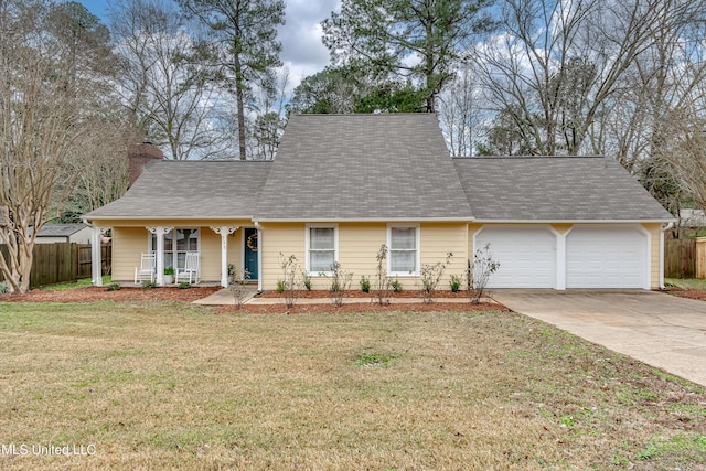 ranch-style home featuring a garage, covered porch, and a front yard