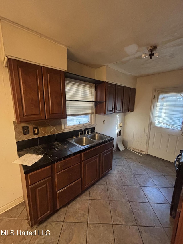 kitchen featuring tasteful backsplash, tile patterned flooring, and a sink