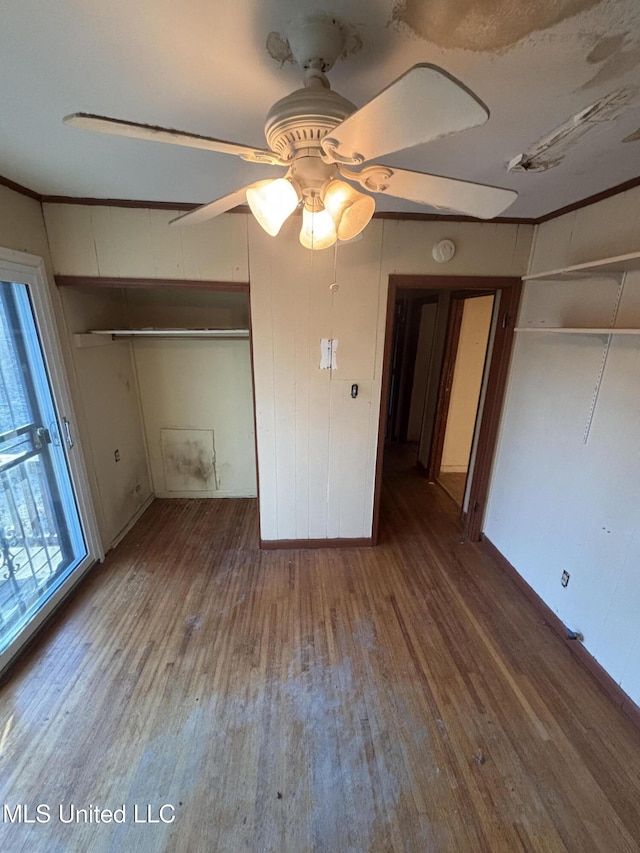 unfurnished bedroom featuring ornamental molding, a ceiling fan, and wood finished floors