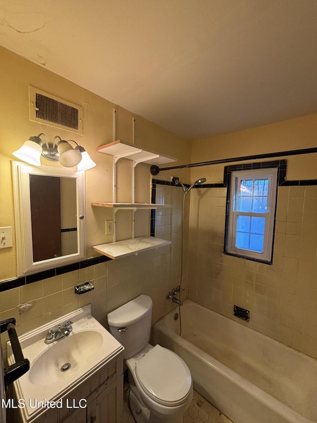 full bathroom featuring tile walls, shower / bathtub combination, visible vents, toilet, and vanity