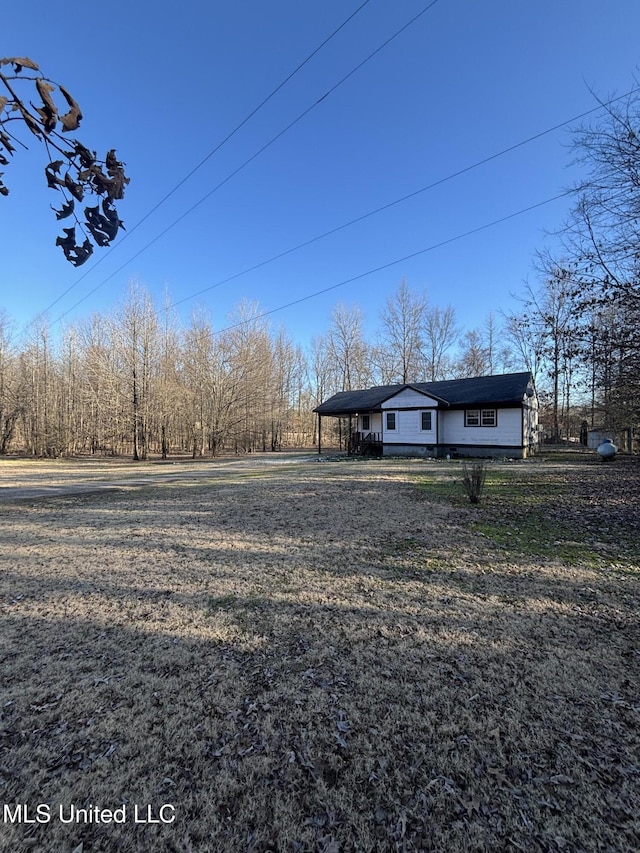 view of yard with driveway and an attached carport