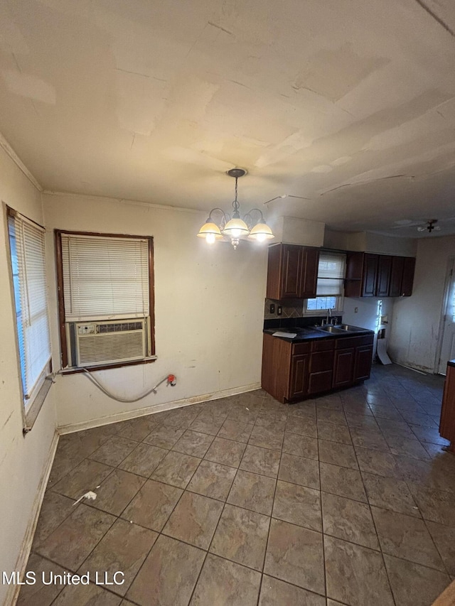 kitchen with dark countertops, a wealth of natural light, cooling unit, and a notable chandelier