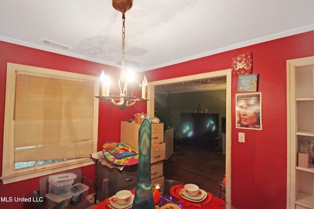 dining space with crown molding and a chandelier