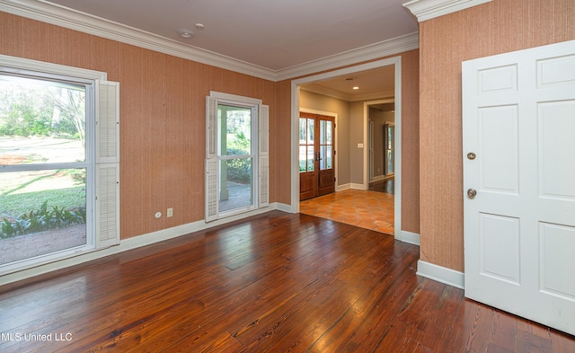 empty room featuring ornamental molding, dark wood-style flooring, plenty of natural light, and baseboards