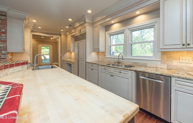 kitchen with stainless steel dishwasher, tasteful backsplash, plenty of natural light, and a sink