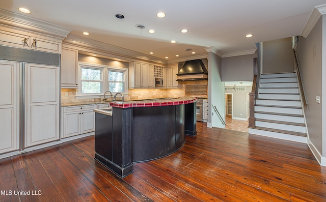 kitchen with dark wood-style floors, backsplash, custom exhaust hood, and crown molding