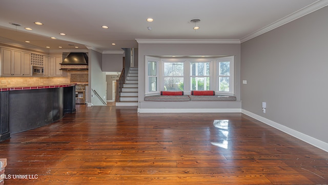 unfurnished living room featuring dark wood-style flooring, visible vents, baseboards, ornamental molding, and stairway