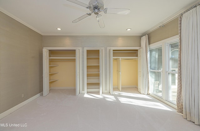 unfurnished bedroom featuring baseboards, access to exterior, carpet, crown molding, and multiple closets