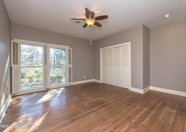 unfurnished bedroom with a ceiling fan, a closet, baseboards, and hardwood / wood-style flooring