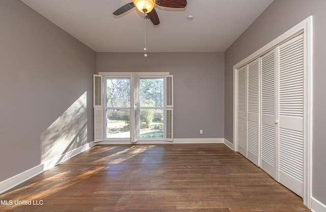 unfurnished bedroom with a ceiling fan, a closet, baseboards, and wood finished floors