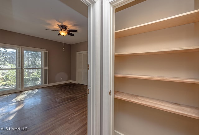 unfurnished room featuring wood finished floors, a ceiling fan, and baseboards