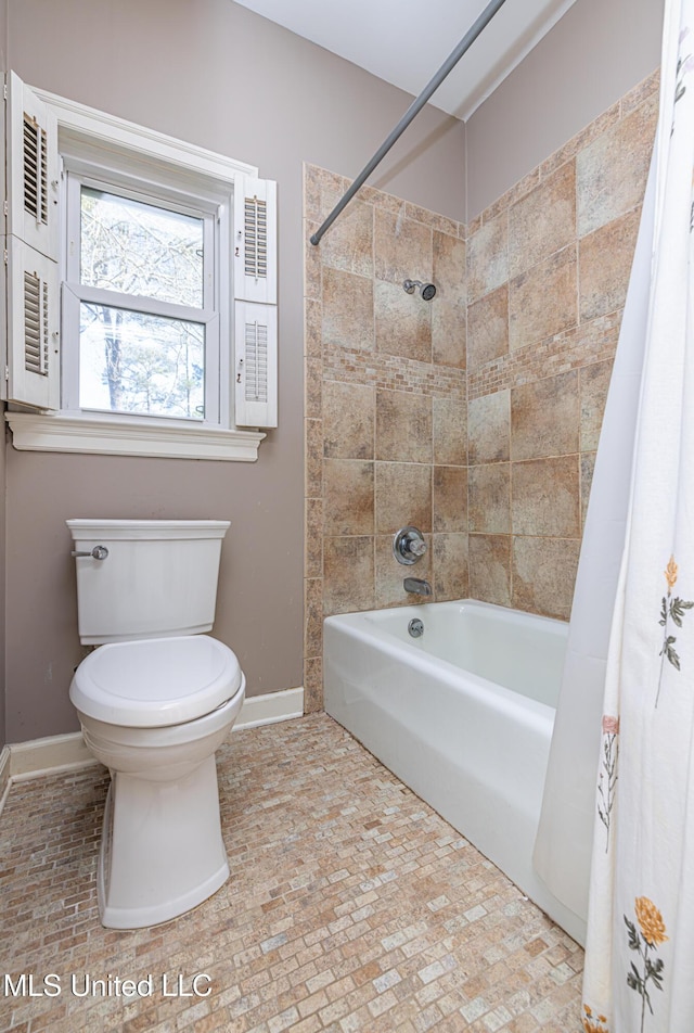 full bathroom with shower / bathtub combination with curtain, toilet, and baseboards