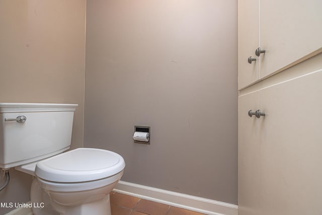 bathroom with toilet, tile patterned flooring, and baseboards