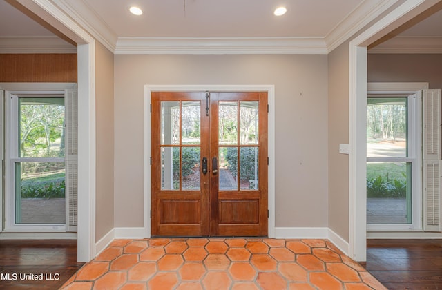 entryway featuring crown molding, baseboards, and a wealth of natural light