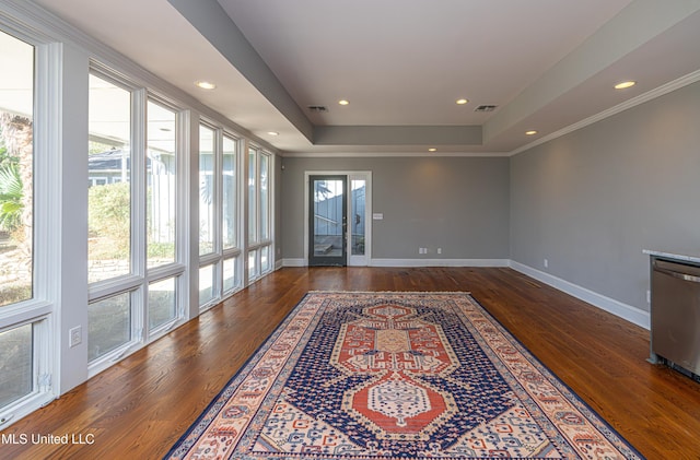 interior space with visible vents, baseboards, wood finished floors, a tray ceiling, and recessed lighting