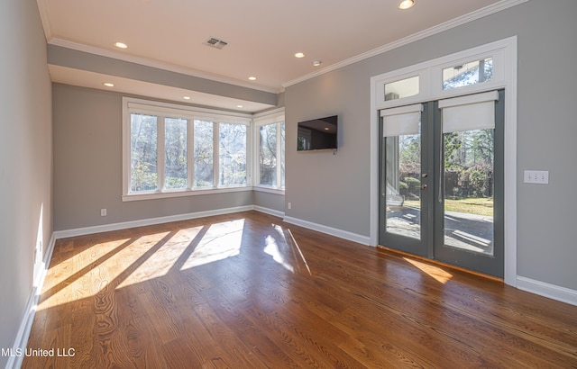 interior space with wood finished floors, visible vents, baseboards, french doors, and crown molding