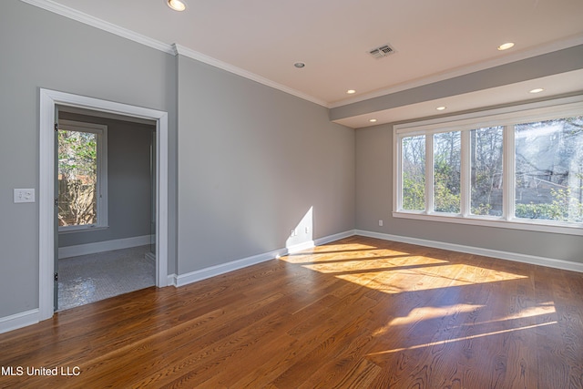 empty room featuring recessed lighting, visible vents, ornamental molding, wood finished floors, and baseboards