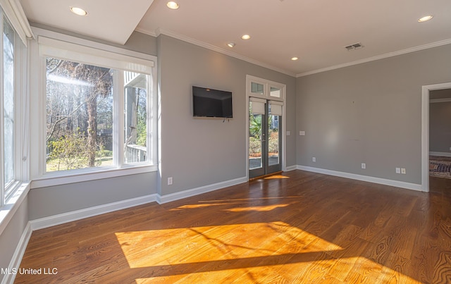 unfurnished living room with a healthy amount of sunlight, visible vents, and wood finished floors