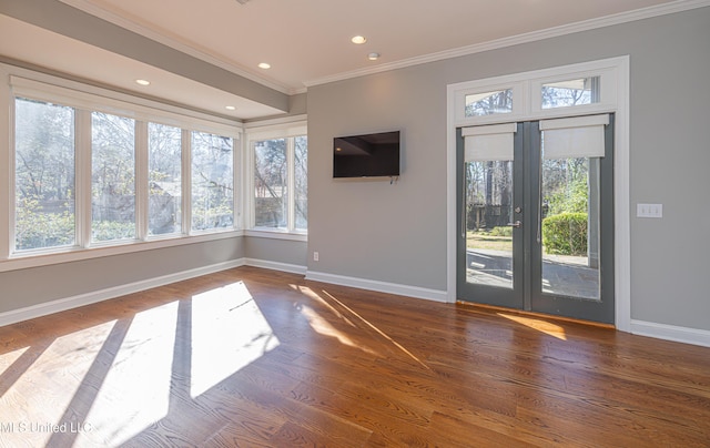 unfurnished living room with crown molding, plenty of natural light, and baseboards