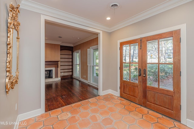 entrance foyer featuring baseboards, visible vents, ornamental molding, french doors, and a fireplace