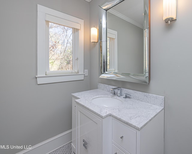 bathroom featuring ornamental molding, vanity, and baseboards