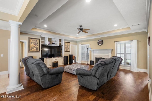 108 Merlot Cv, Clinton, MS 39056 - living room with decorative columns, baseboards, a ceiling fan, a tray ceiling, and dark wood-type flooring