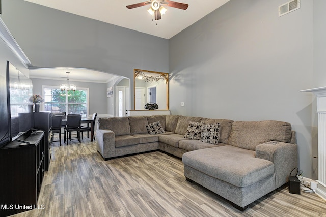 9821 Morgan Manor Dr, Olive Branch, MS 38654 - living area featuring ceiling fan, a chandelier, arched walkways, light wood-type flooring, and crown molding