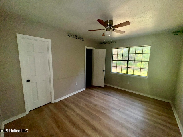 unfurnished bedroom featuring ceiling fan, hardwood / wood-style flooring, and a textured ceiling