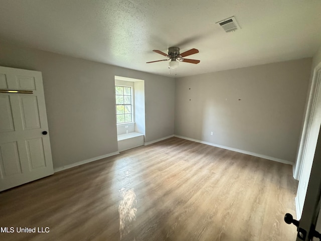 empty room featuring light hardwood / wood-style flooring, a textured ceiling, and ceiling fan