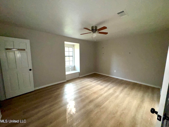 spare room with ceiling fan and hardwood / wood-style flooring