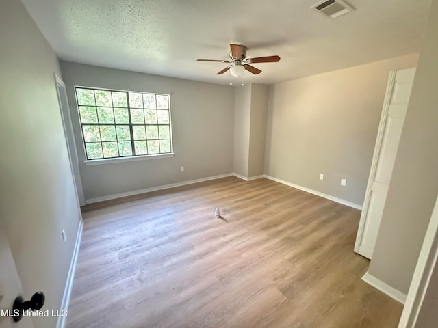 spare room featuring light hardwood / wood-style flooring, a textured ceiling, and ceiling fan