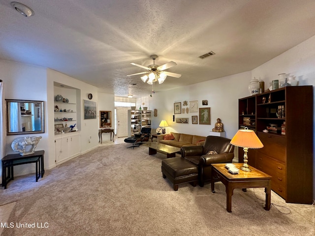 living room featuring a textured ceiling, carpet, and ceiling fan