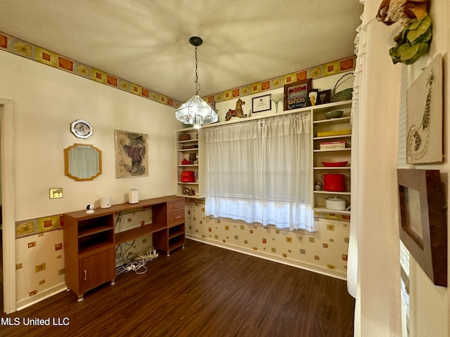 misc room with an inviting chandelier, a textured ceiling, and dark wood-type flooring