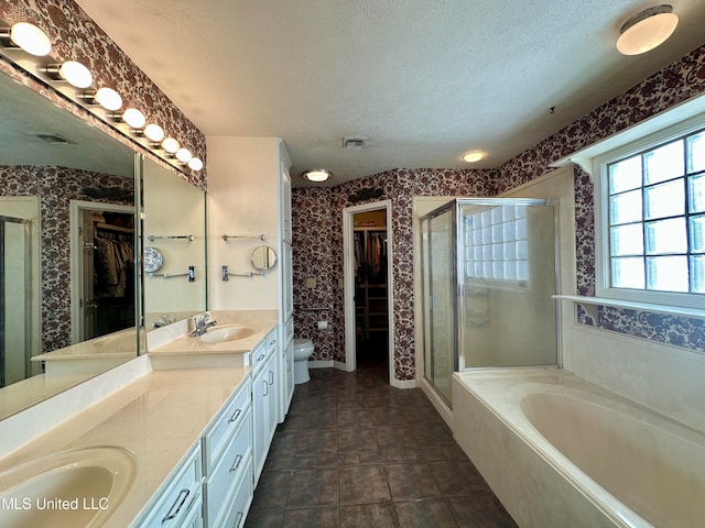 full bathroom featuring toilet, a textured ceiling, shower with separate bathtub, and vanity