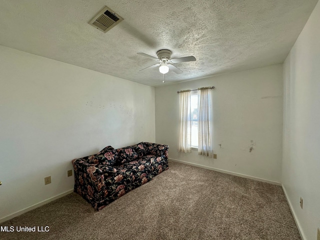 unfurnished room featuring a textured ceiling, carpet floors, and ceiling fan