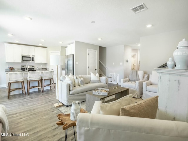 9626 W Oaklawn Rd, Biloxi, MS 39532 - living area featuring light wood-style floors, recessed lighting, and stairs