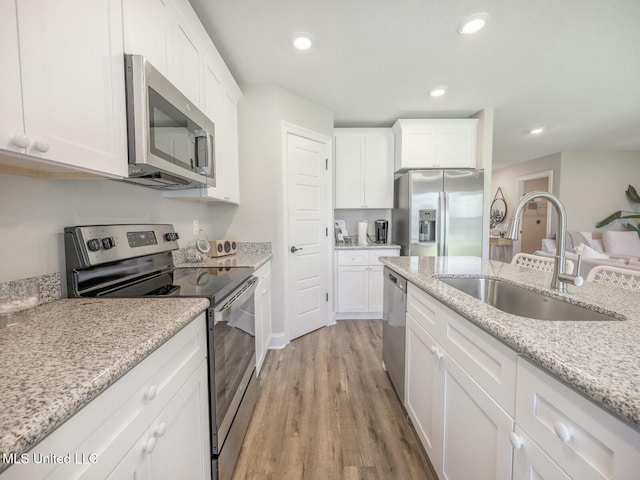 9626 W Oaklawn Rd, Biloxi, MS 39532 - kitchen with stainless steel appliances, white cabinetry, light wood finished floors, recessed lighting, and light stone counters