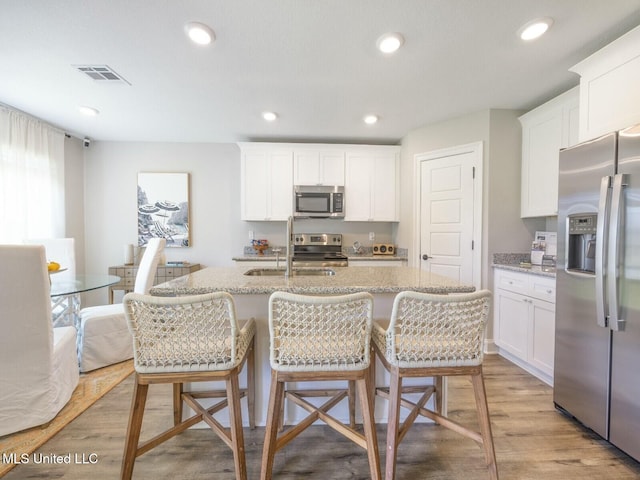 9626 W Oaklawn Rd, Biloxi, MS 39532 - kitchen with appliances with stainless steel finishes, light wood-type flooring, white cabinets, and recessed lighting