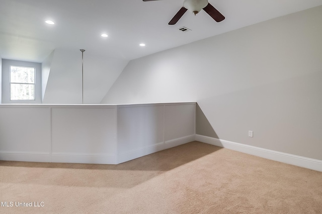 spare room with ceiling fan, light colored carpet, and lofted ceiling