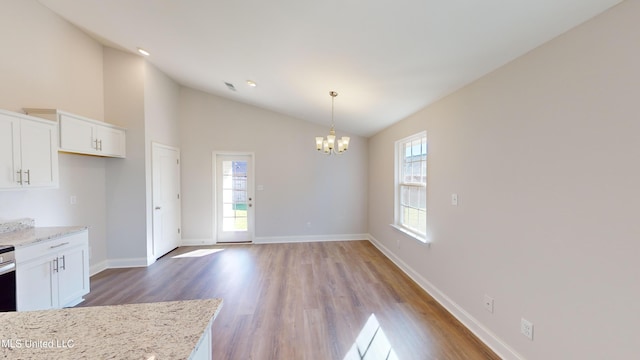 7876 Gardendale Dr, Olive Branch, MS 38654 - kitchen featuring a chandelier, white cabinetry, light wood-type flooring, hanging light fixtures, and high vaulted ceiling